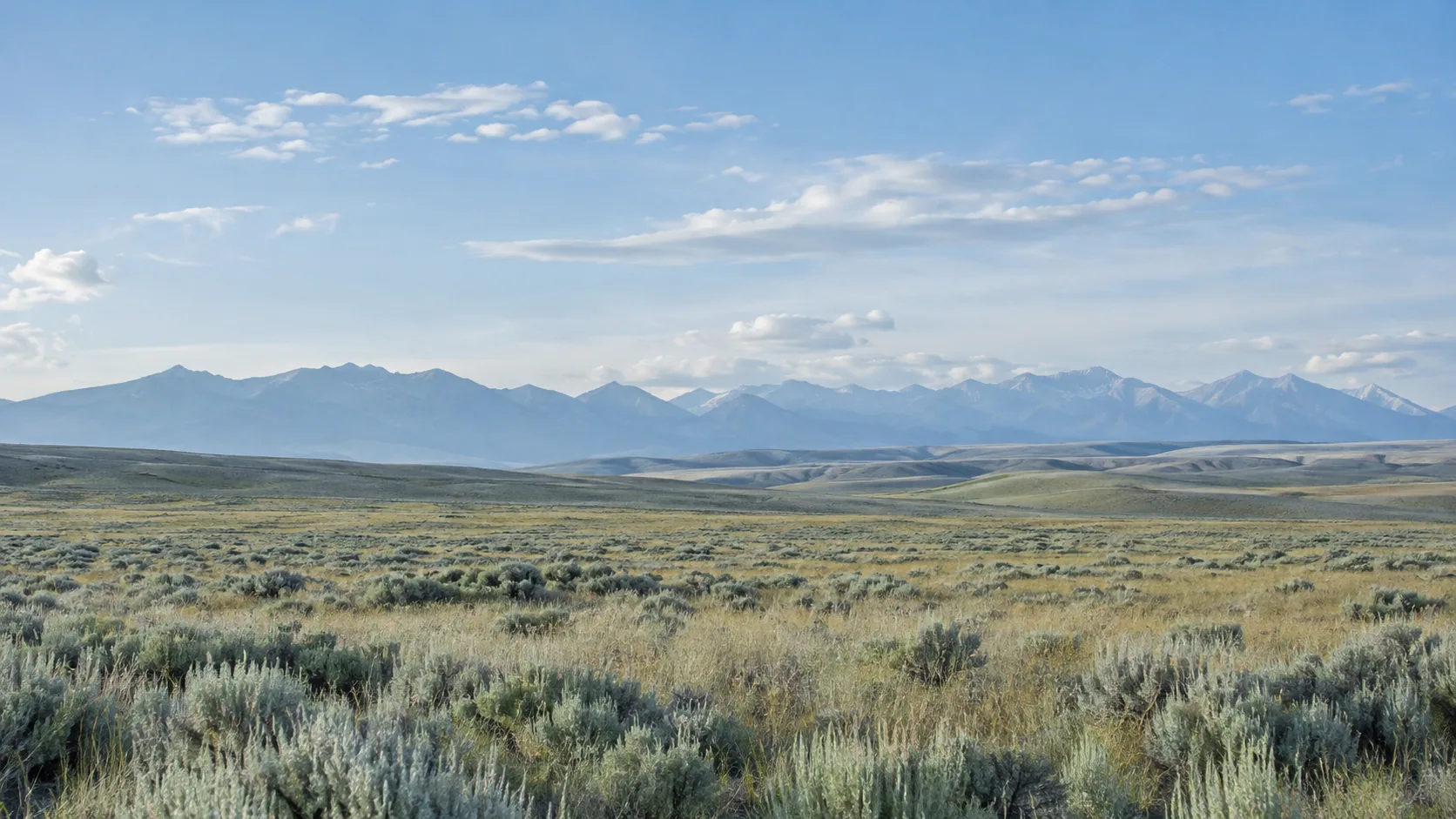 Open Wyoming plains beneath distant mountains